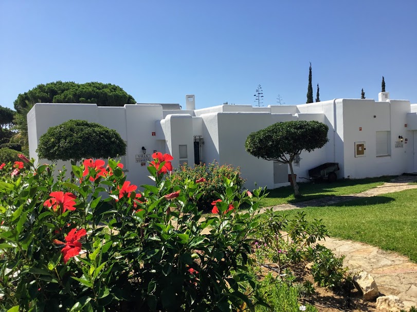 Prado Villas External Prado VIllas exterior of villas surrounded by grass and red hibiscus flowers