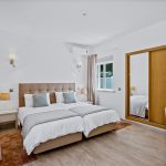 Prado Villas holiday to the Algarvebedroom with two single beds, wardrobe morror, window and desk.