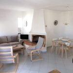 Prado do Golf - interior of lounge with grey sofas and dining table in dining room with 4 chairs.