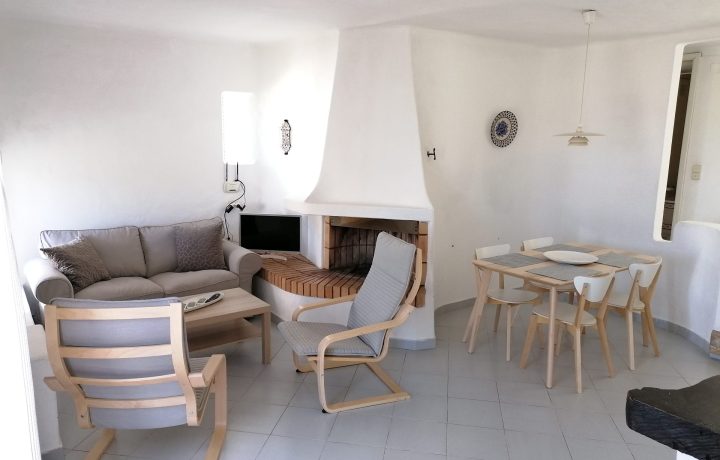 Prado do Golf - interior of lounge with grey sofas and dining table in dining room with 4 chairs.