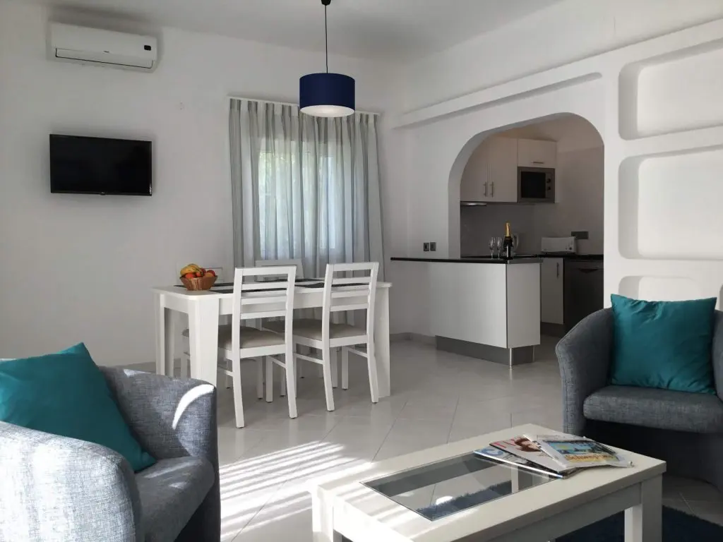 apartamentos ferias vilamoura algarve apartamentos férias Vilamoura com mesa e cadeiras brancas e sofa cinzento