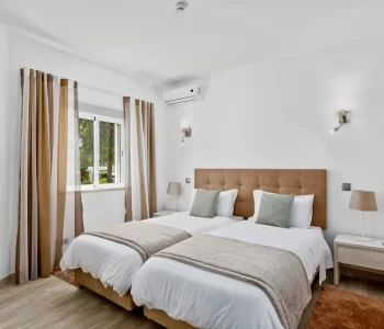 Algarve-Holiday-villas-Prado-Villas-Vilamoura Bedroom with two beds. white covers with brown and cream curtains
