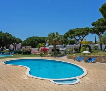 Large pool surrounded by blue sunbeds