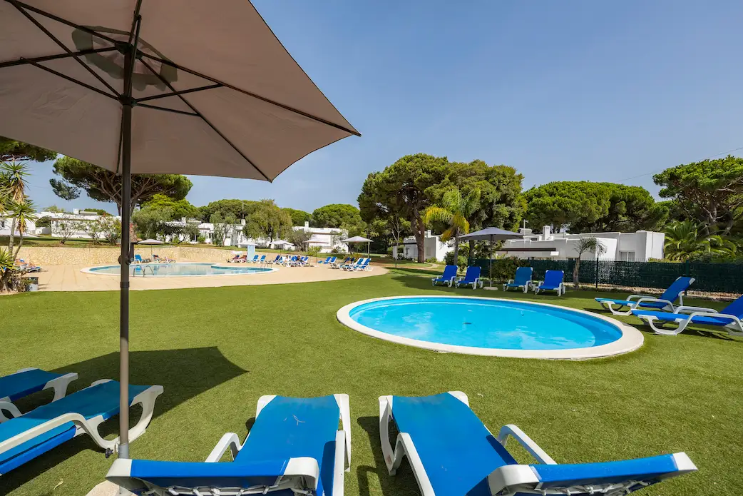 Childrens pool area with blue sunbeds and green grass